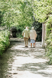 2 alte Menschen gehen einen Weg entlang
